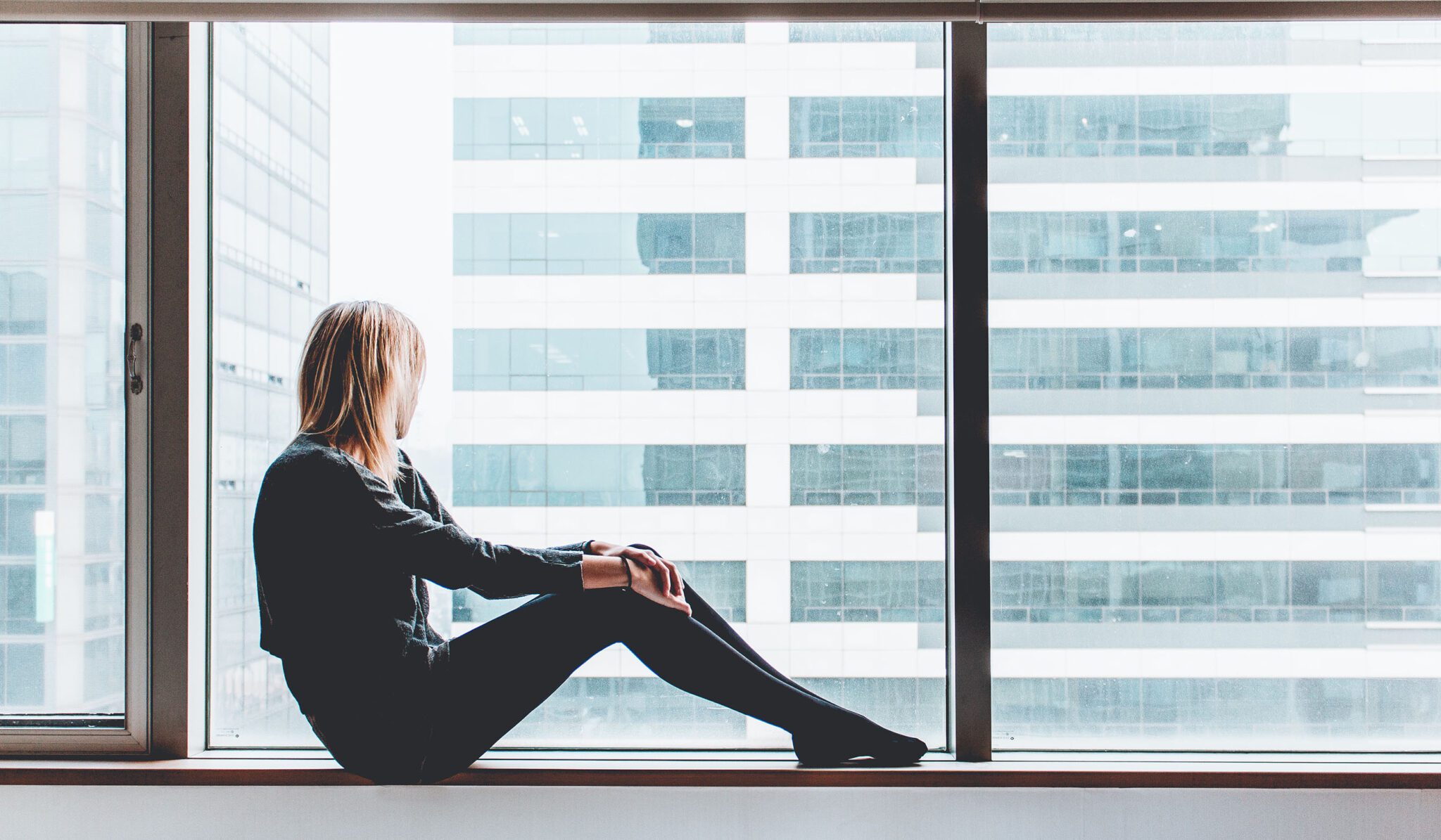 woman considering an at-home fertility test while staring out the window